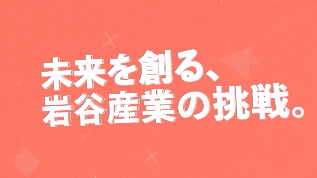 「未来を創る、岩谷産業の挑戦。」という白い文字が、オレンジ色の背景の中央に表示されているタイトル画面の画像。背景には薄くX（エックス）のマークや斜線などの幾何学模様がデザインされている。
